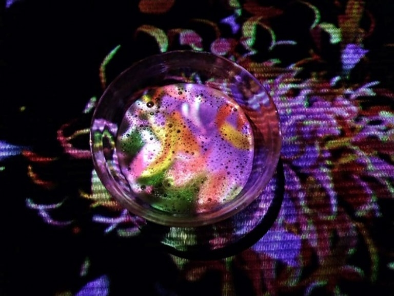 A colorful digital flower grows from inside a teacup