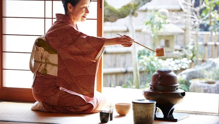 A woman in kimono prepares tea