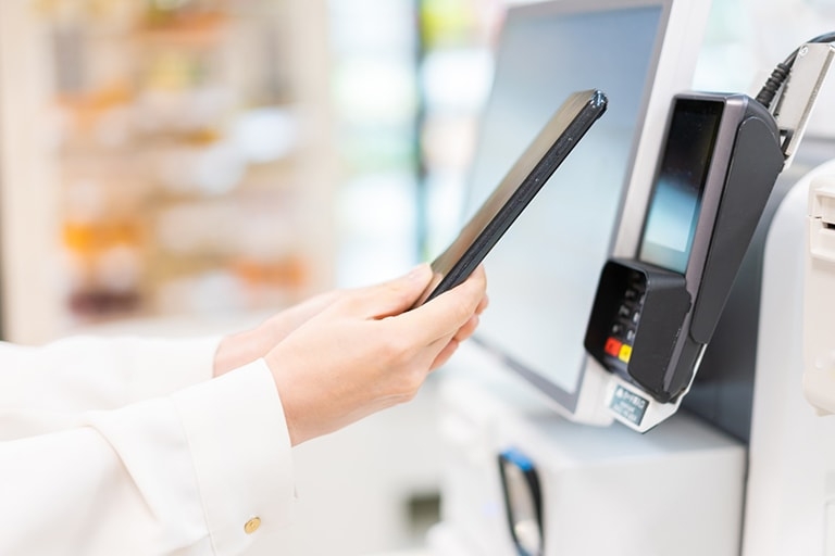 close-up of person using an automatic kiosk to make a transaction