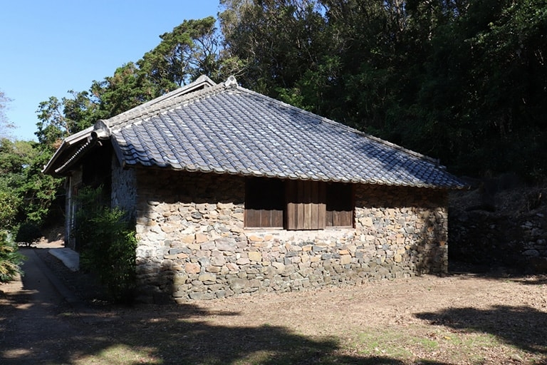 Small stone building next to a forest in Japan