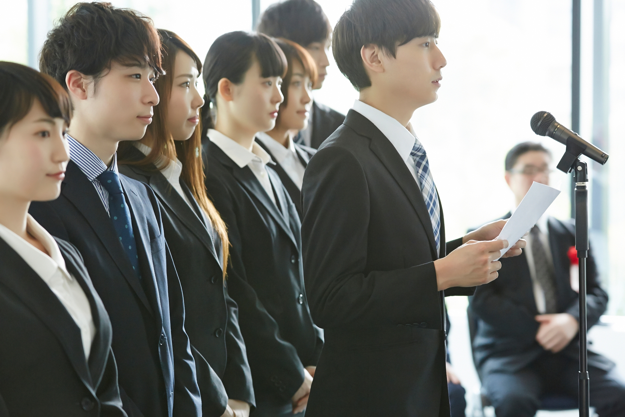 Young employees stand at a company entrance ceremony