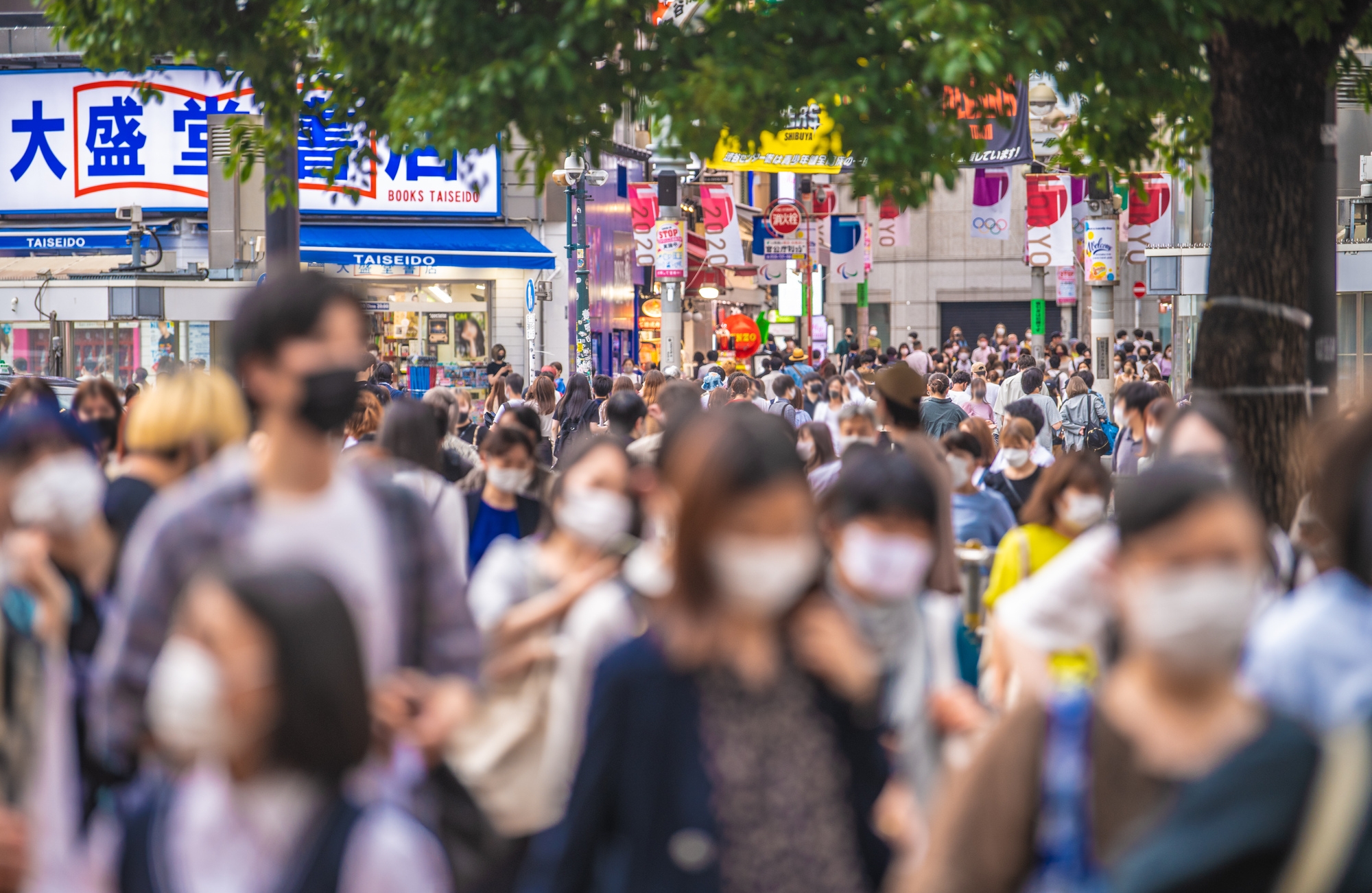 Crowds of people outside in Japan, wearing masks