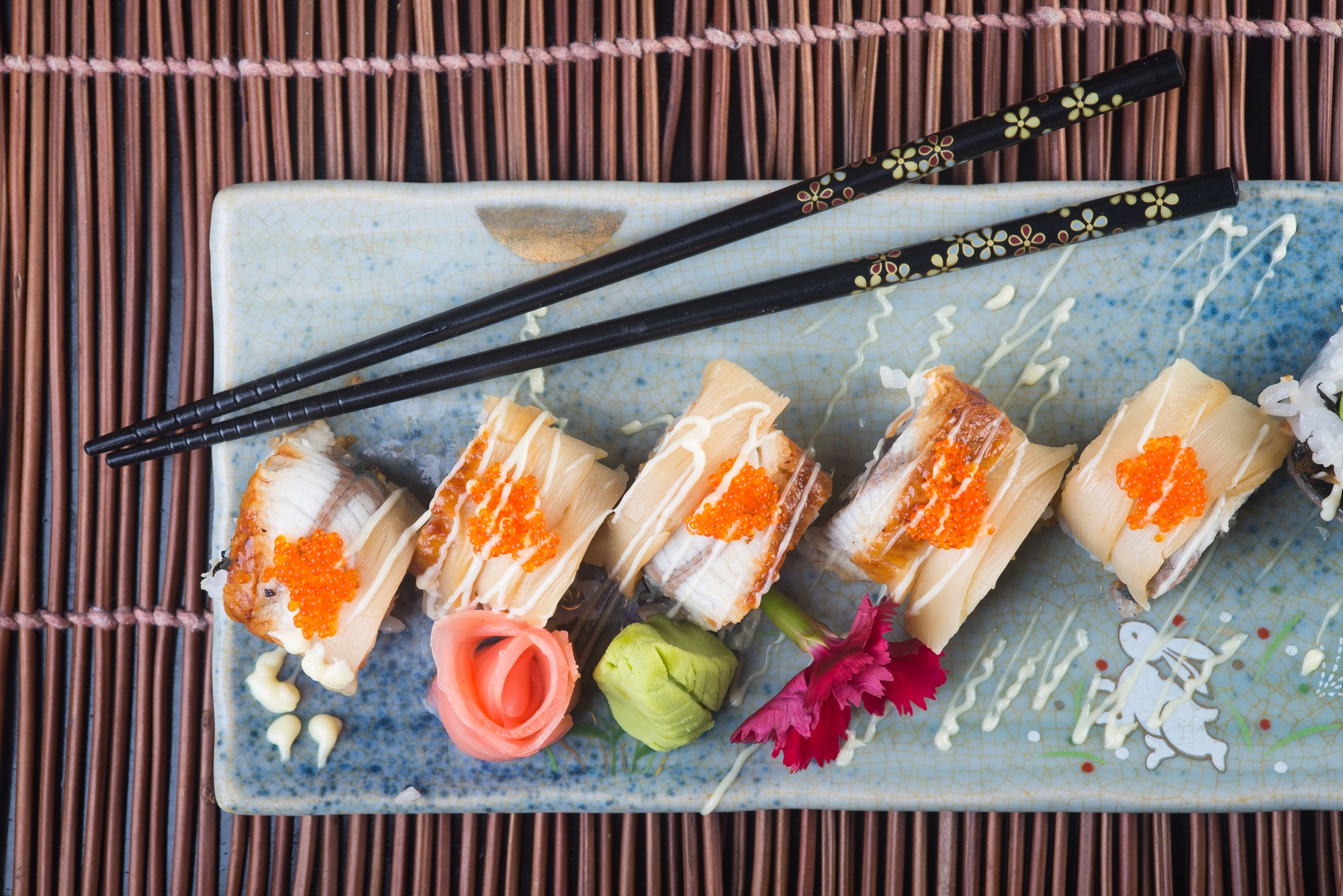 A plate of sushi with chopsticks