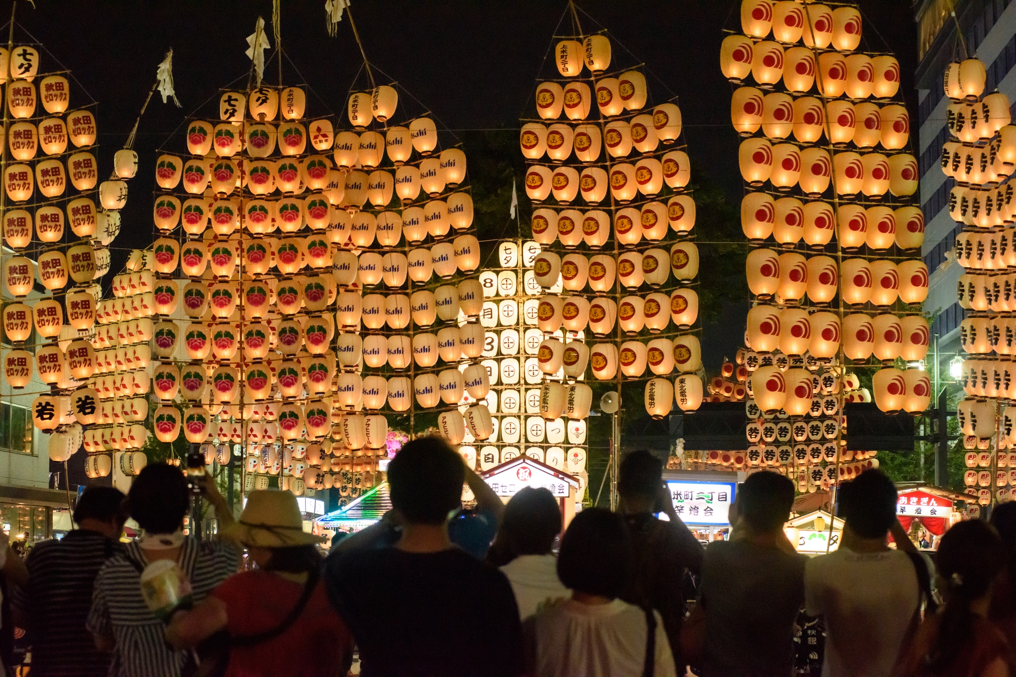 Arrays of paper lamps carried on bamboo poles