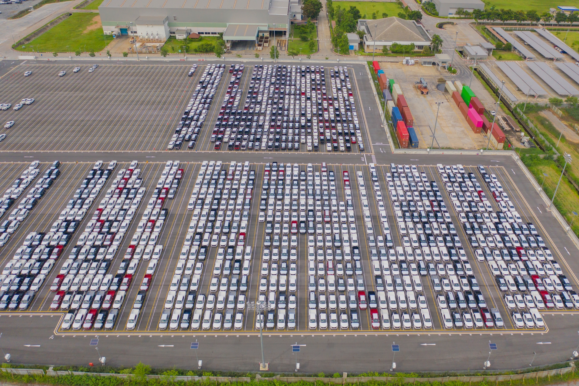 New cars parked outside a manufacturing plant