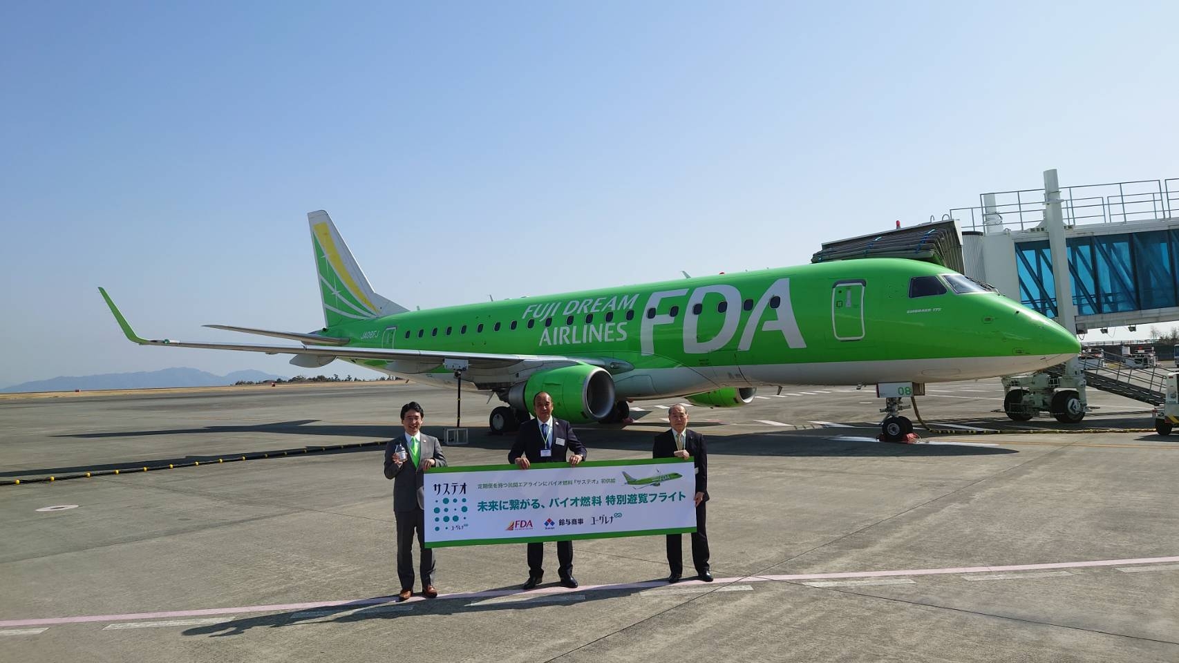 Green jet airplane at an airport, fuelled with Euglena