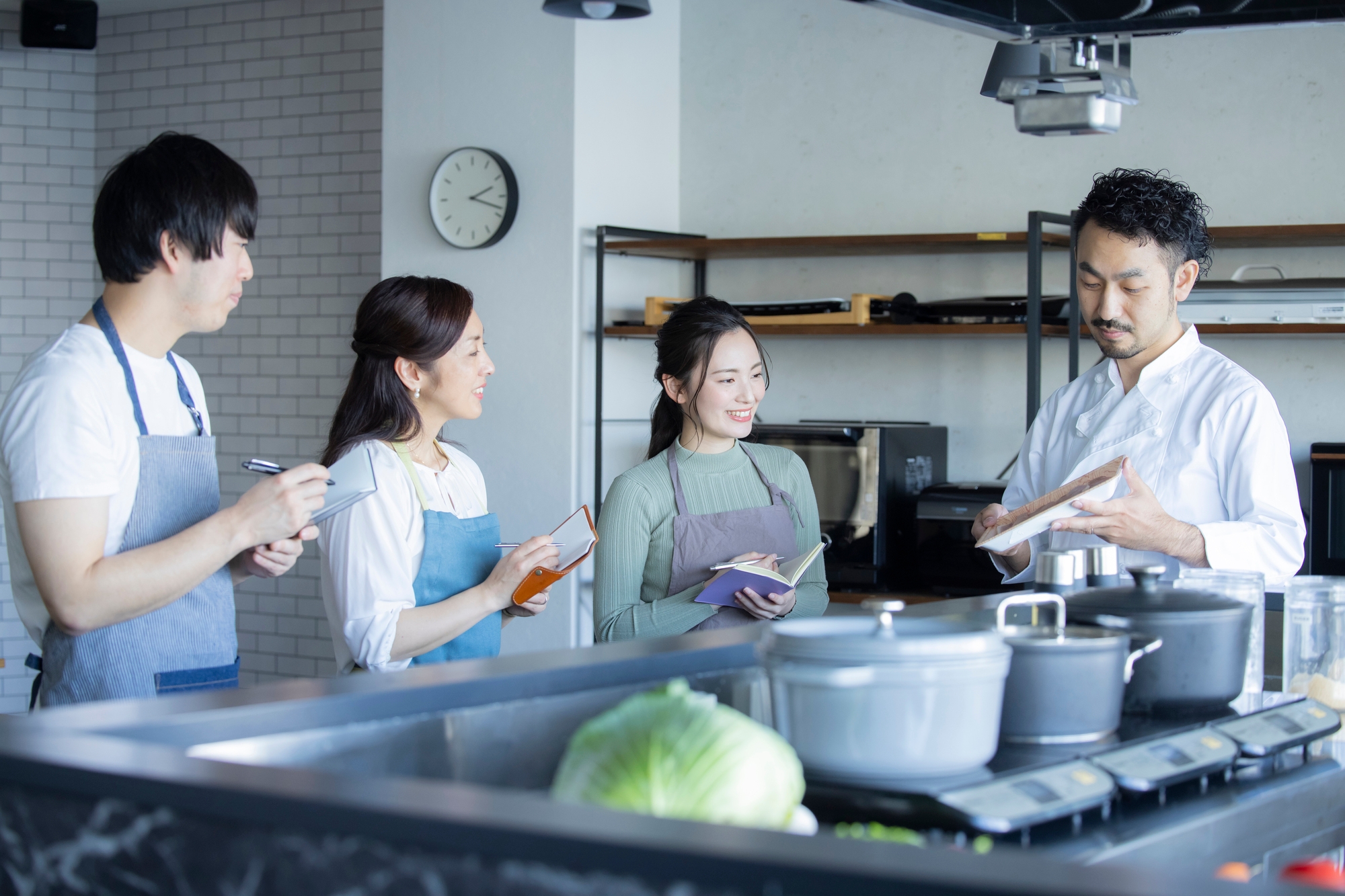 A cooking teacher giving a lesson to three students