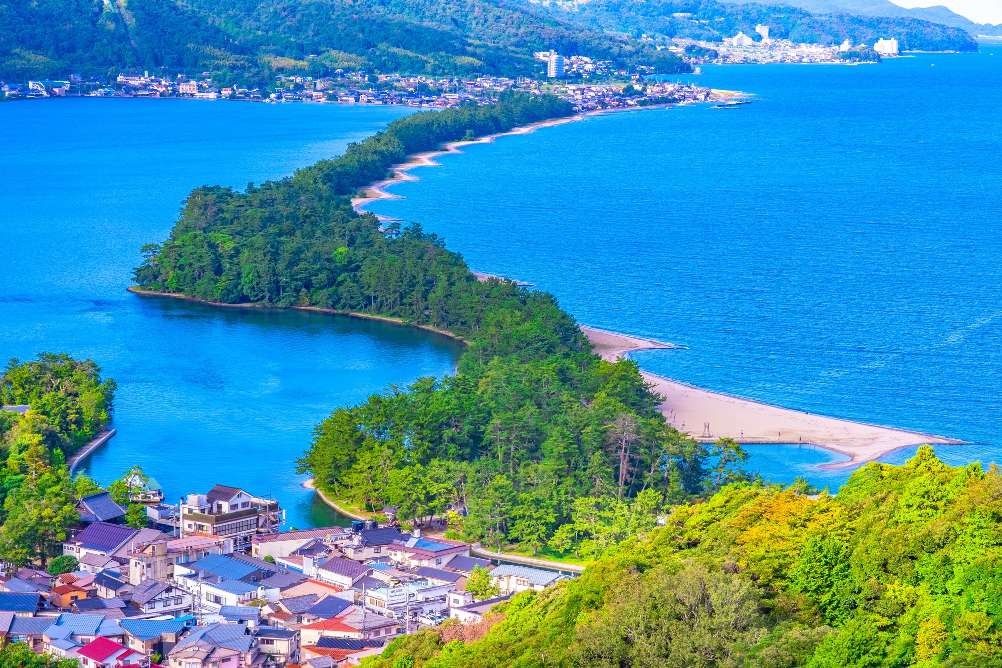 Aerial view of Amanohashidate, and long thin sandbar covered in pine trees