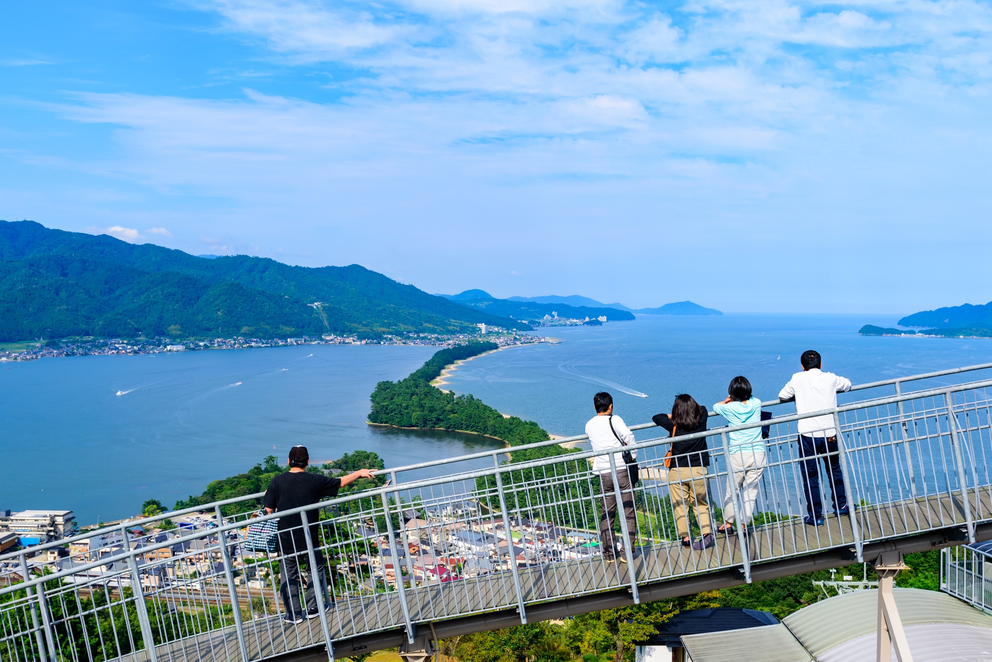 People standing on a high observation deck looking at Amanohashidate