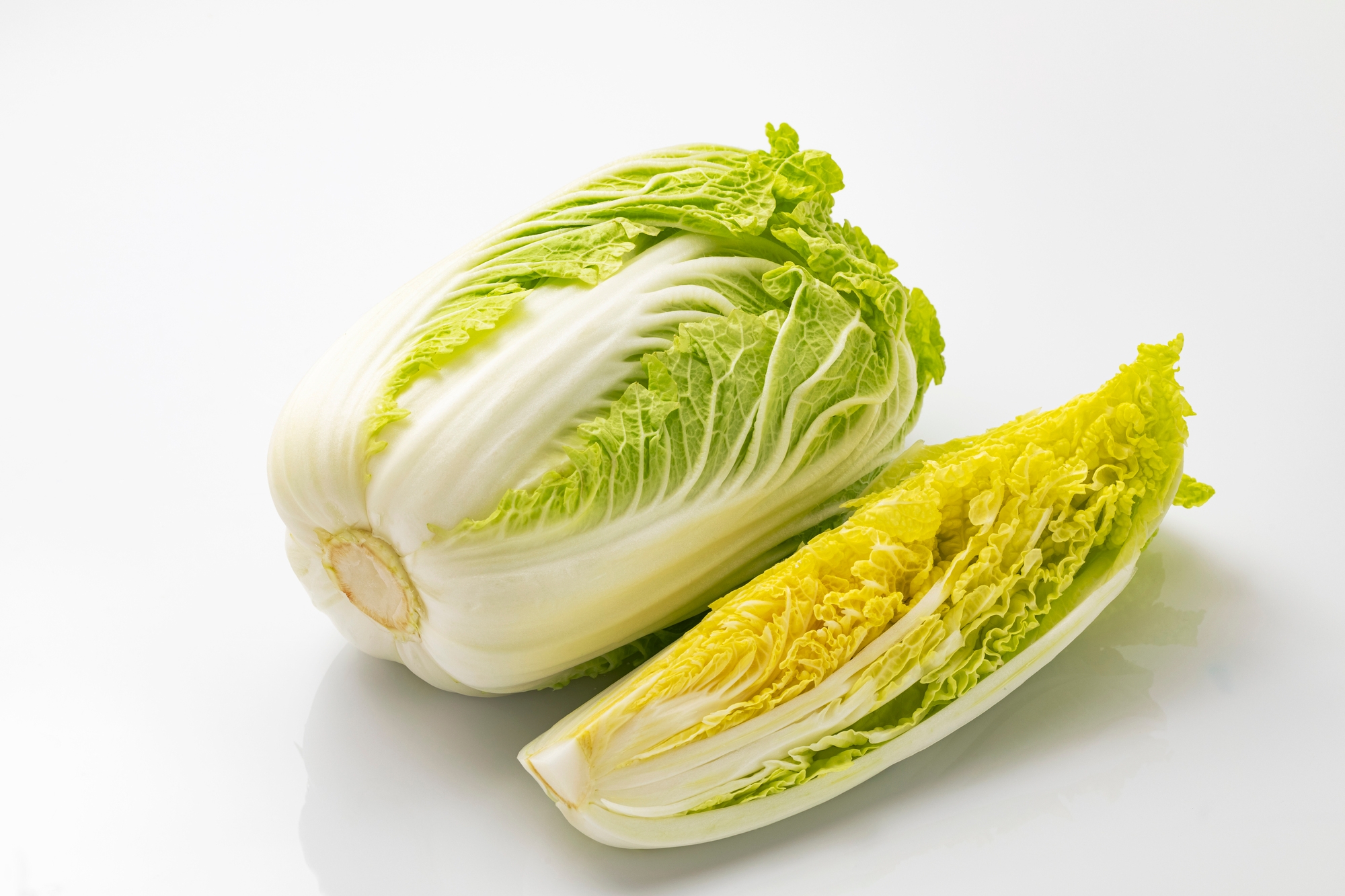 A whole chinese cabbage and a sliced chinese cabbage