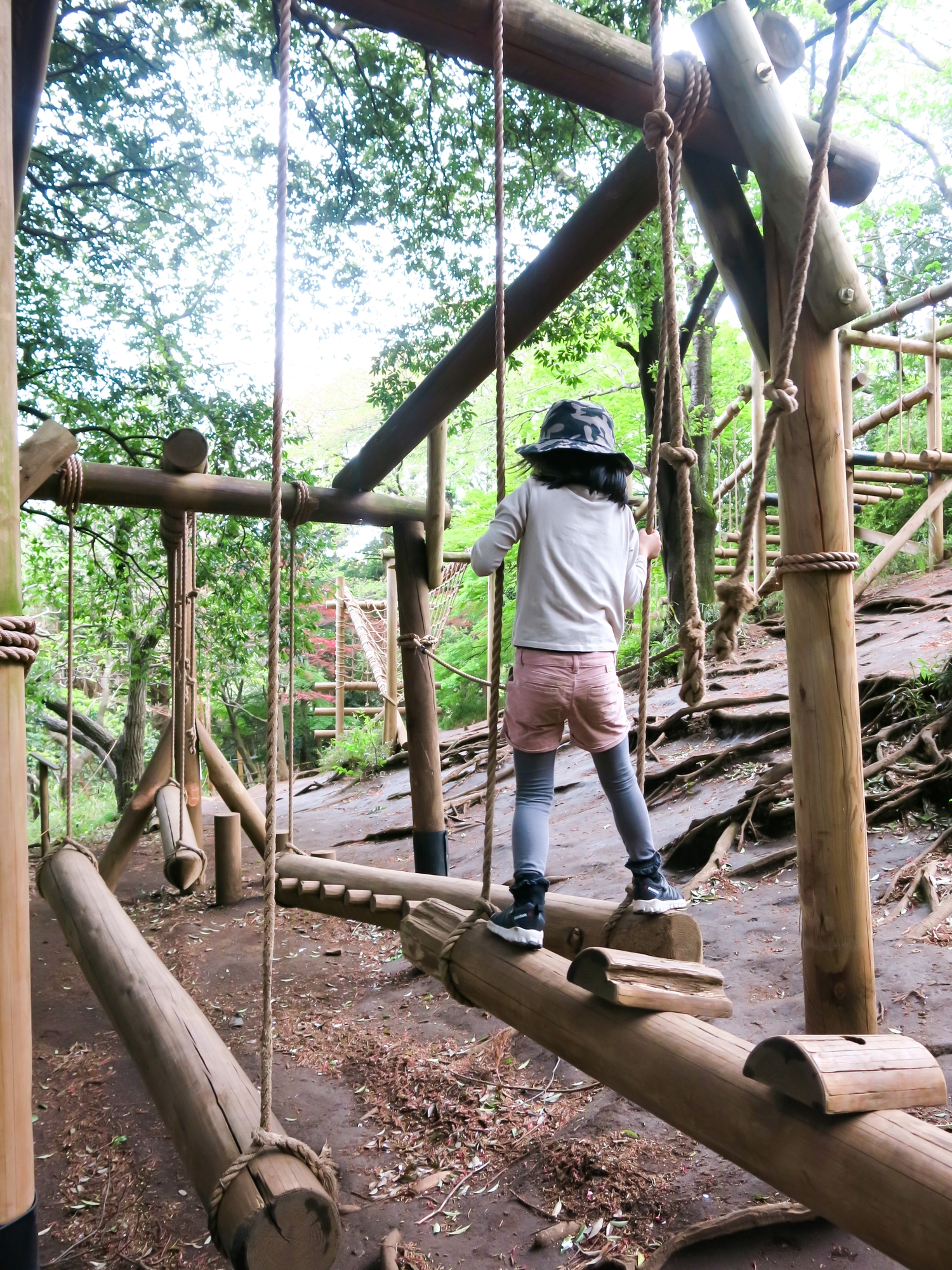 A child climbing through a forest playground