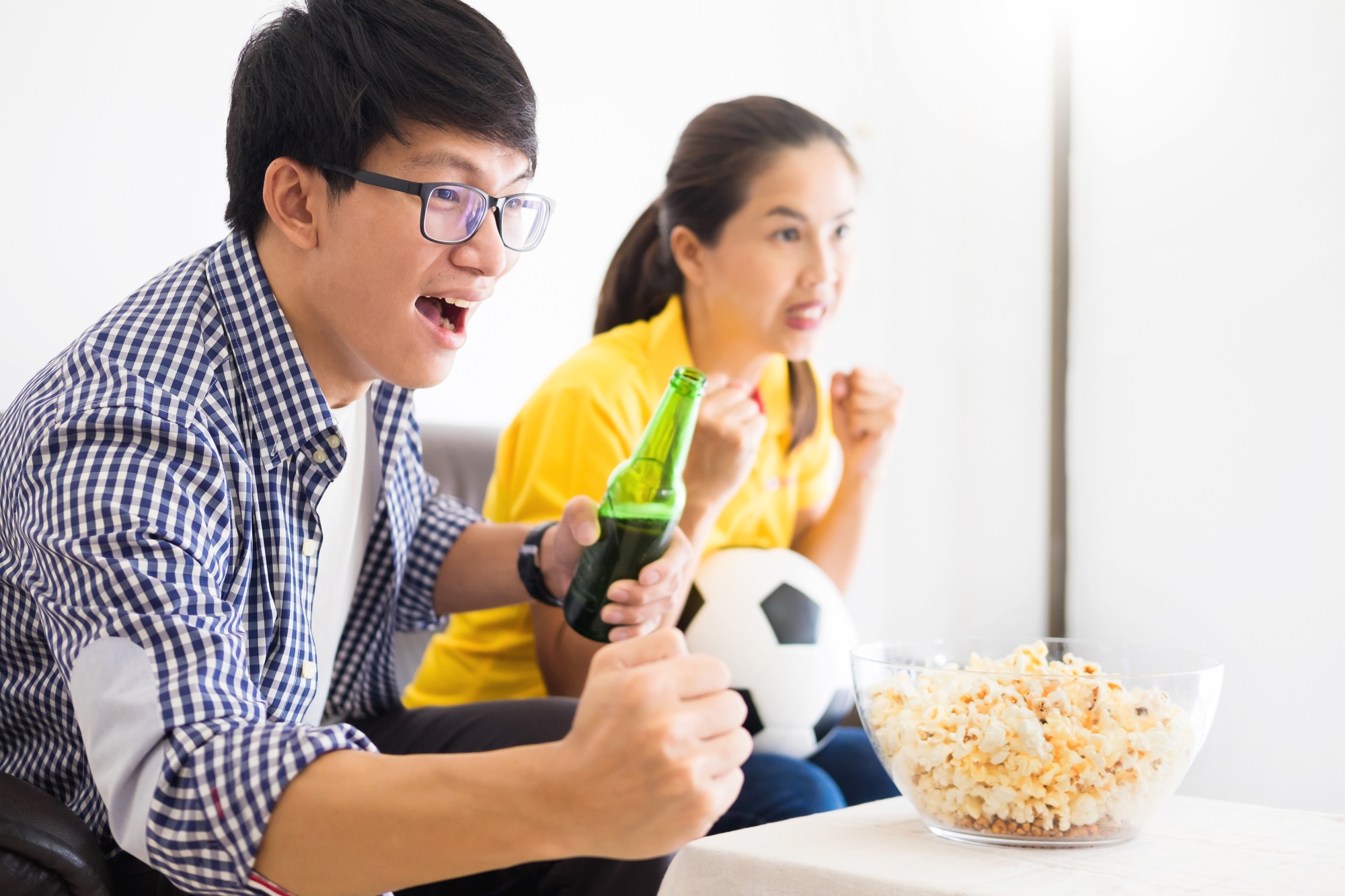 A couple watching a soccer match at home