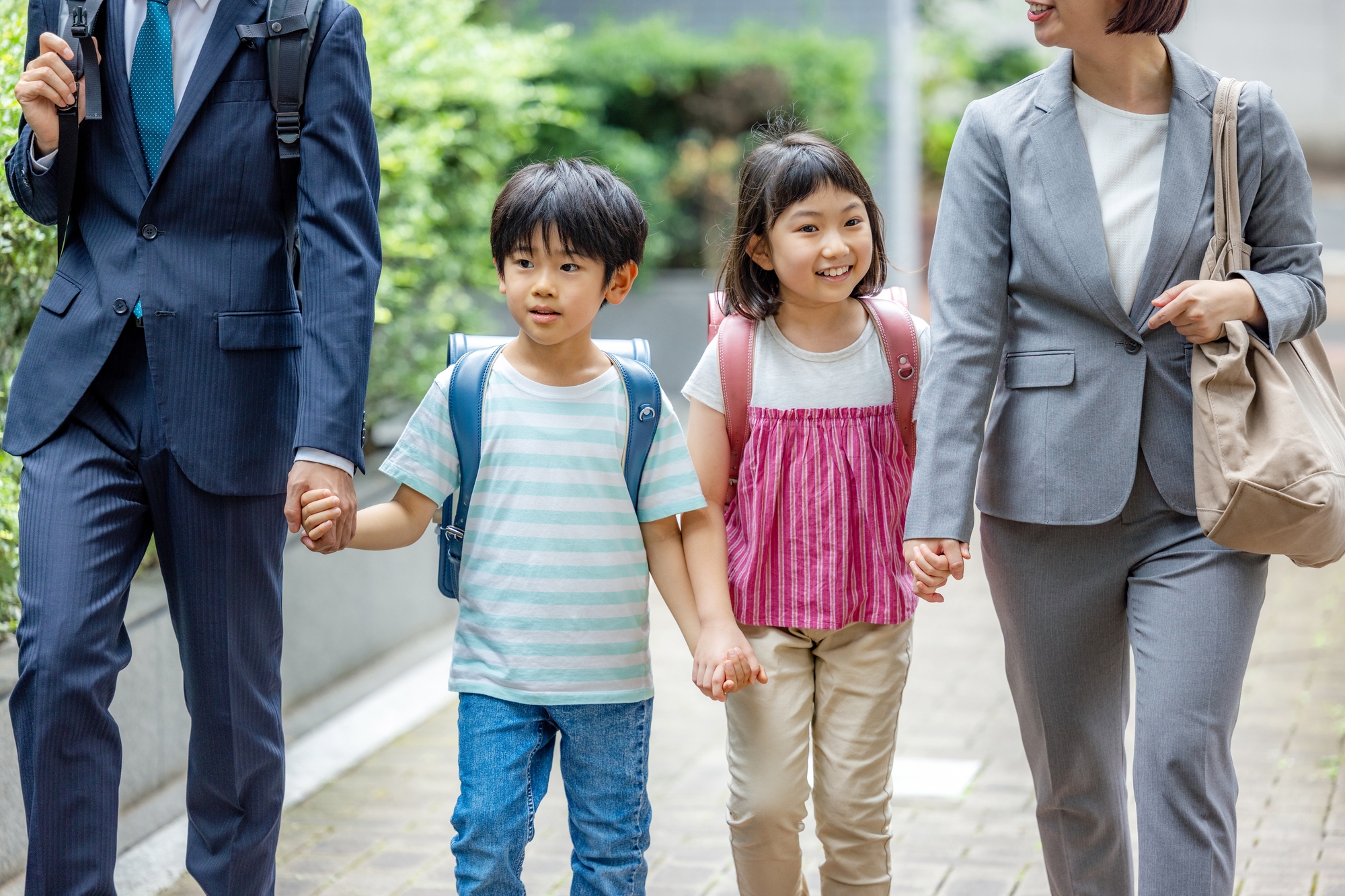 Parents in business suits walking their children to school