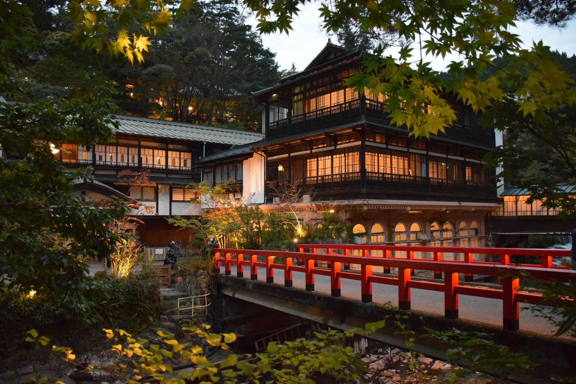 A traditional-style Japanese inn, with a wooden bridge over a river