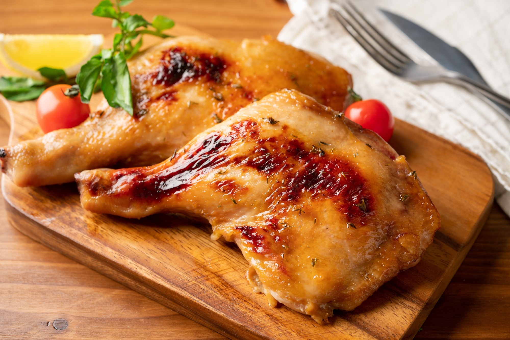 Cooked chicken legs on a wooden board