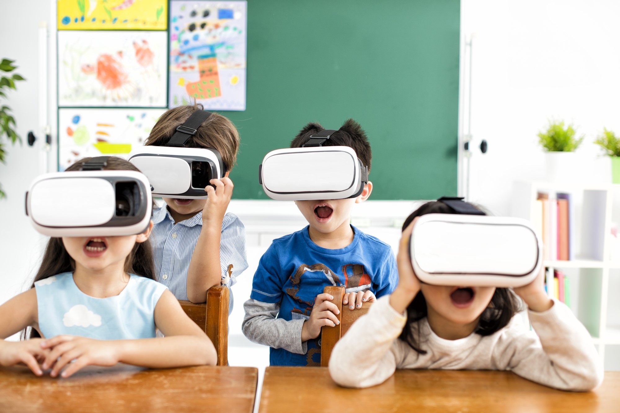 A group of children in a classroom using VR headsets