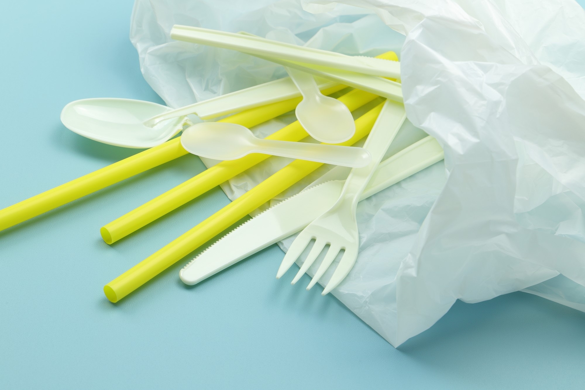 A plastic bag filled with plastic straws and utensils