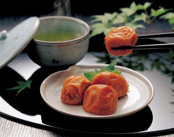 A plate of umeboshi and a cup of green tea