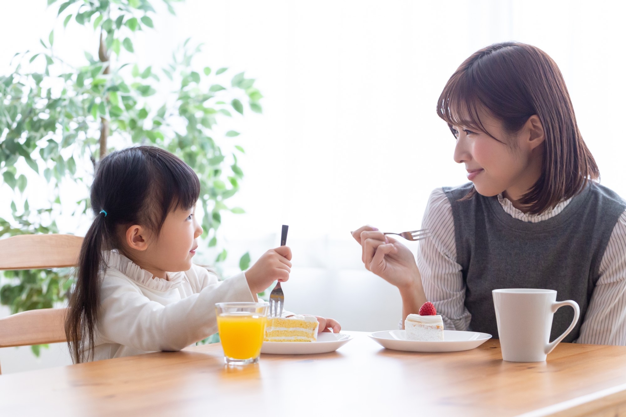 A mother and daughter each eating a piece of cake