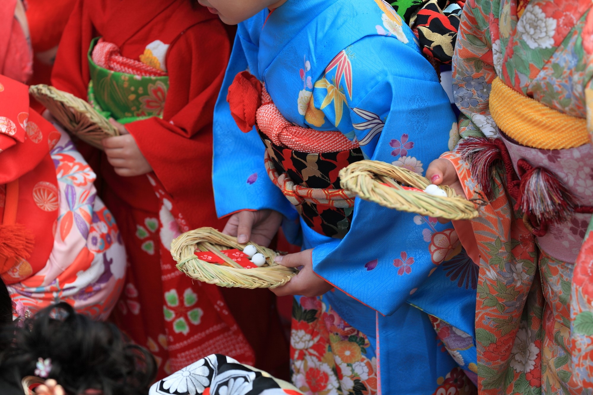 Girls in kimono preparing to float paper dolls in the river