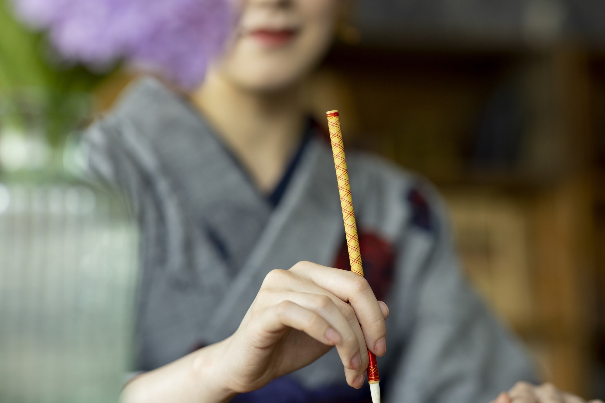 A woman in kimono holding a writing brush