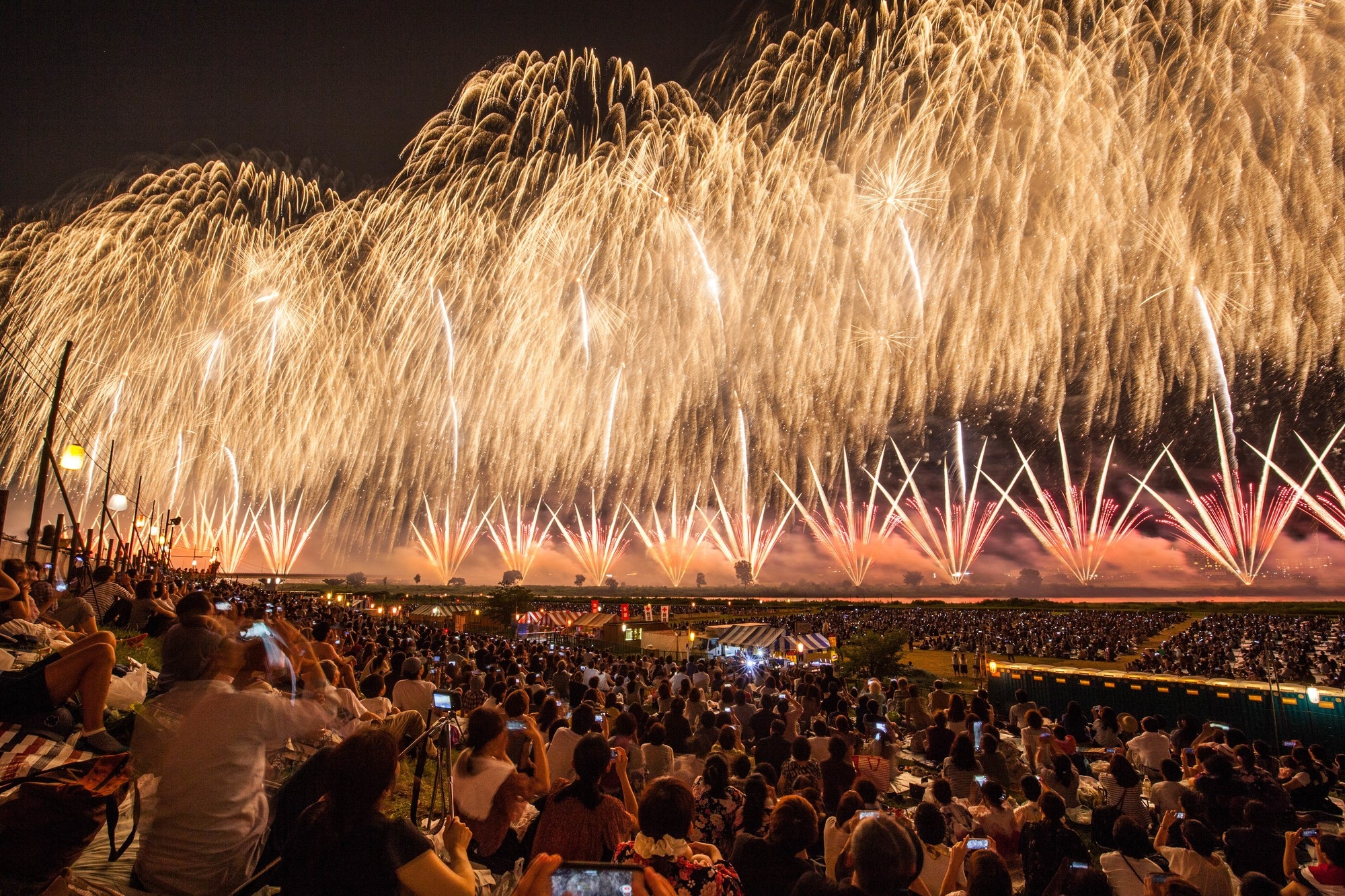 People sitting and looking up the sky to see golden fireworks