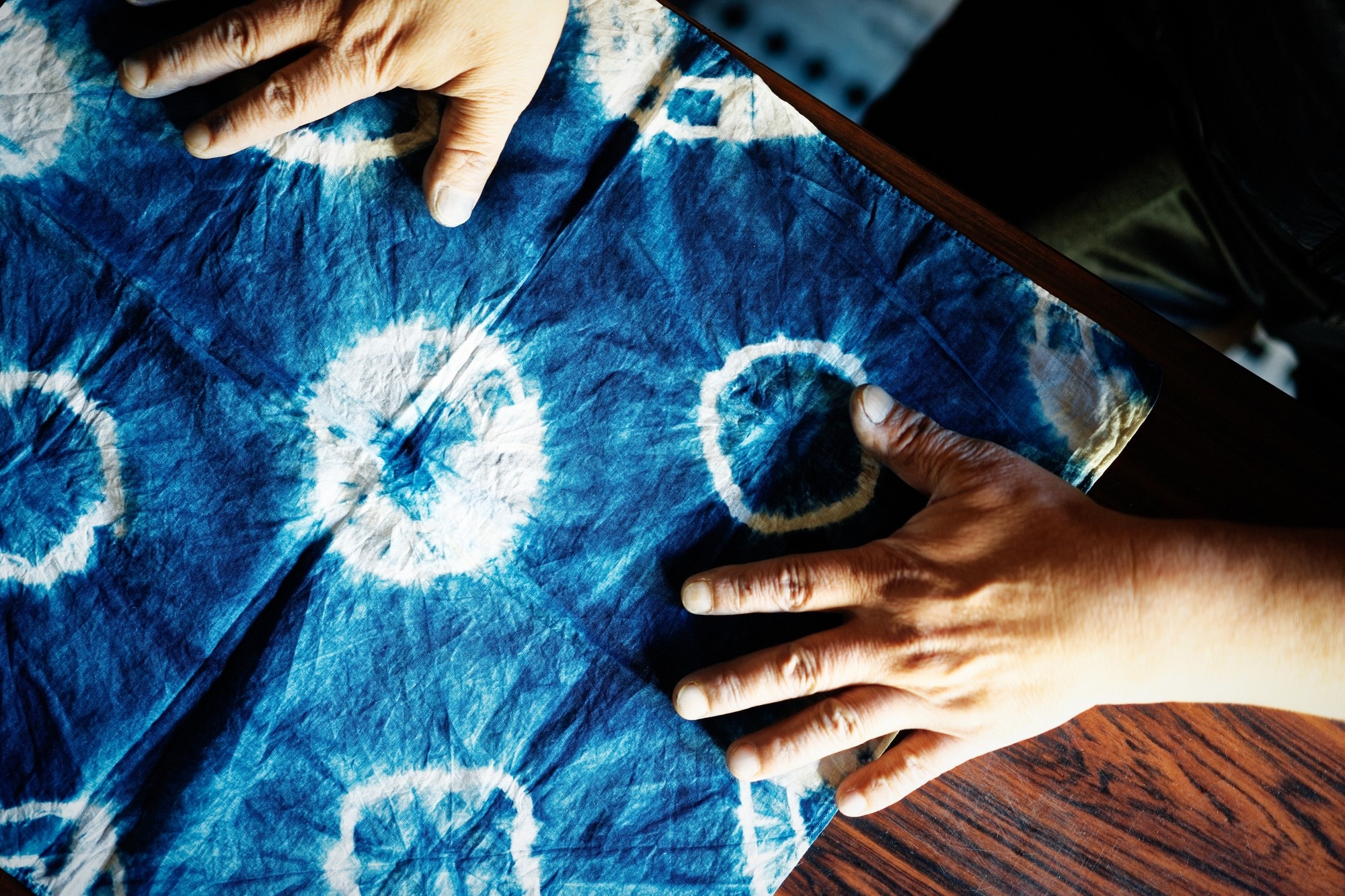 Hands placed on an indigo colored cloth