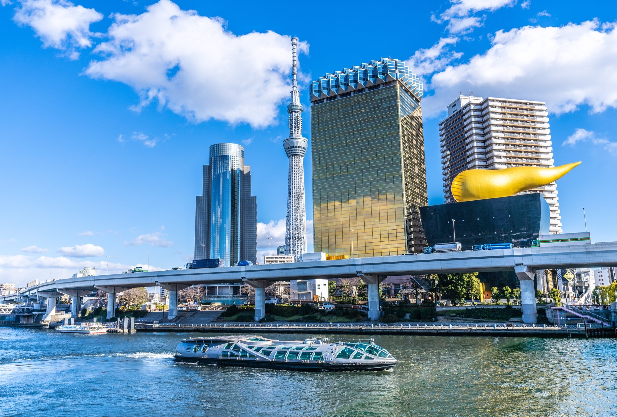 A boat running on the Sumida River and Tokyo Skytree, with skyscrapers