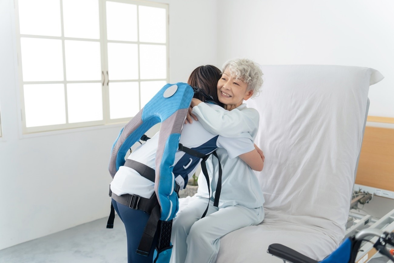 An elderly woman hugging the nursing care staff